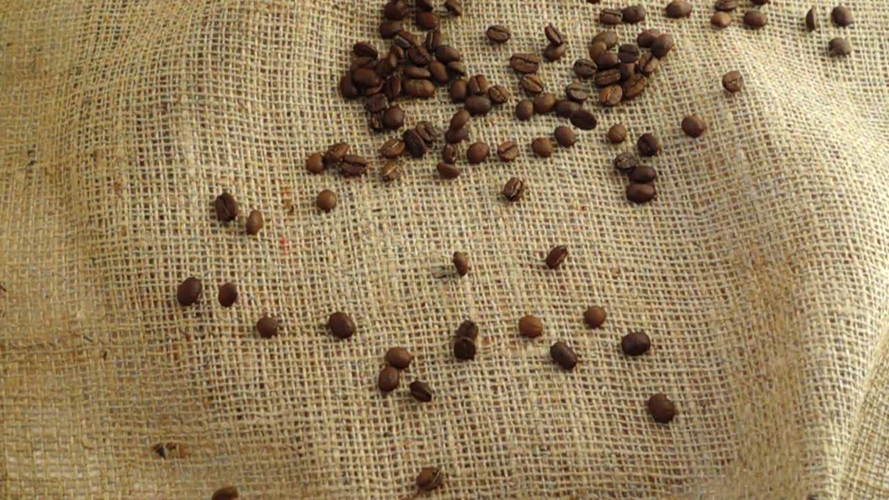 Grãos de café caindo sobre estopa. Câmera lenta.