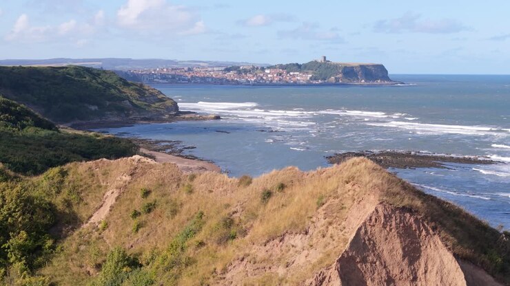 aerial drone footage of Cornelian Bay, Scarborough with blue sky and ocean and big waves