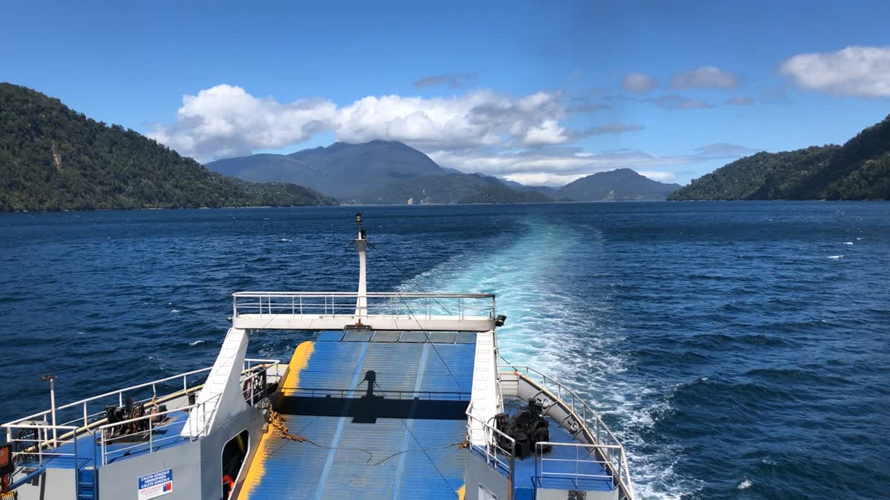 vista de la parte trasera de un ferry navegando por las montañas, al sur de chile.