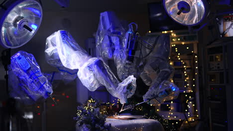 dark operational room with da vinci equipment and decorated for christmas. robotic arms in plastic moving to write with writing pen.