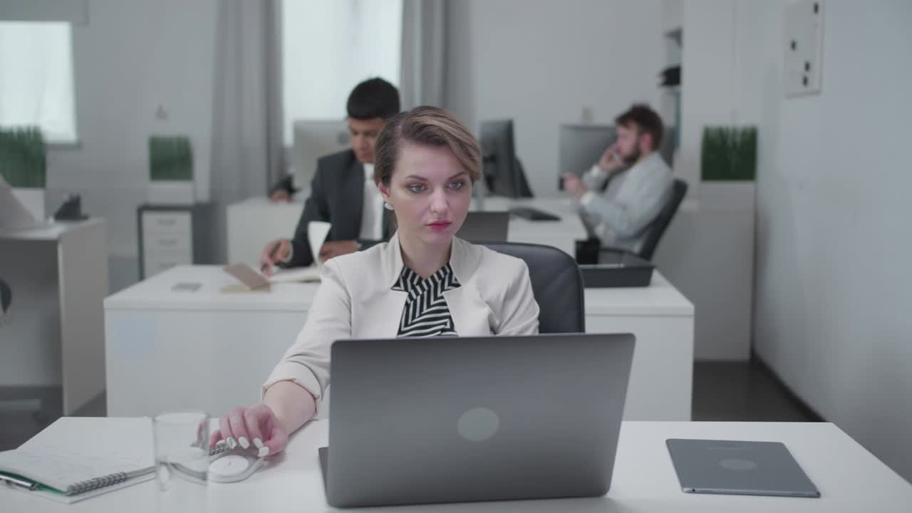 Young woman sit at a table and work at a laptop