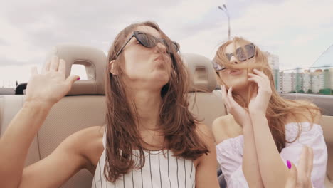 two friends having fun in a convertible car