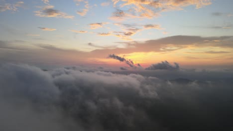 drone flight over mist and fluffy white clouds during colorful sunset, 4k