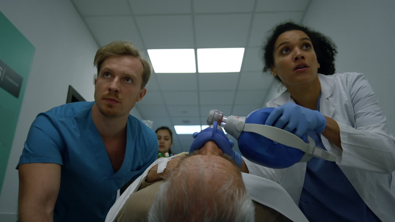 обеспокоенная медицинская группа толкает пациента на носилке в больничном коридоре.