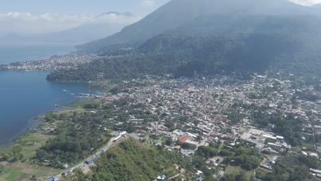 aerial view of san juan la laguna, showcasing lago atitlan, surrounding hills, dense town buildings and greenery