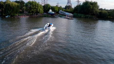 boat sailing on urban river. aerial view of moving boat on urban river