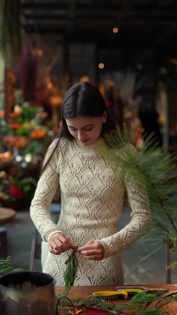 mujer haciendo un arreglo floral de navidad