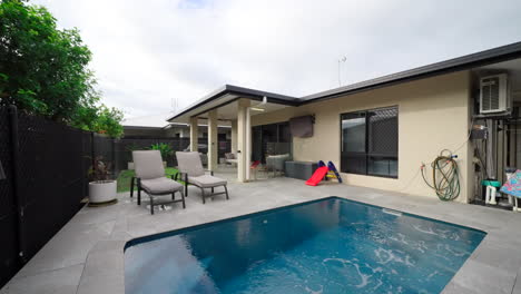 concrete backyard with rectangular pool and blue tiles in tropical region