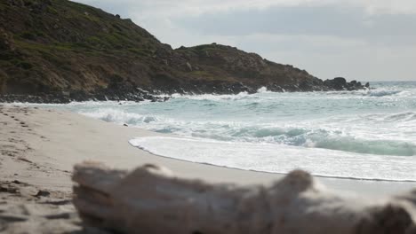 rhythmic waves gently crash onto the shore, creating a soothing symphony of sound. the foamy surf dances across the golden sand, inviting beachgoers to enjoy the calming beauty of the ocean.