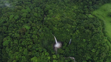 orbiting aerial around foggy volcanic la fortuna waterfall costa rica, 4k