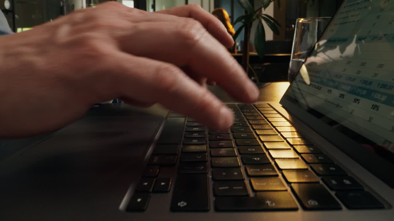 Person Typing on Laptop with Financial Data