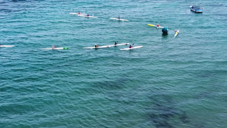 surf ski competitors rotating on a sea buoy in a competition