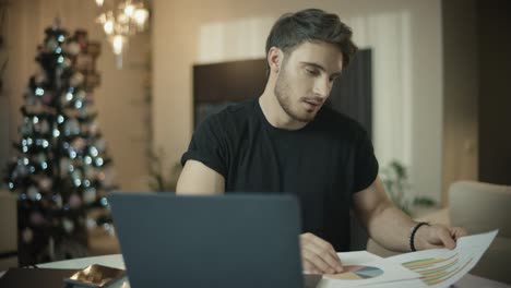 Young-businessman-working-with-documents-at-christmas.-Husband-working-at-winter