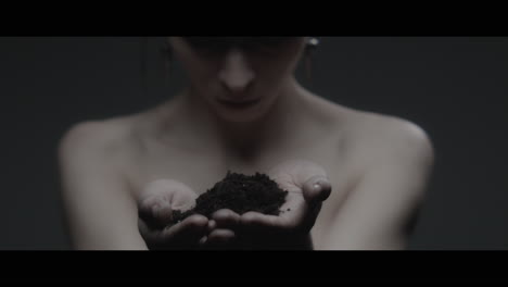 a woman dressed as mother nature holds soil in her hands