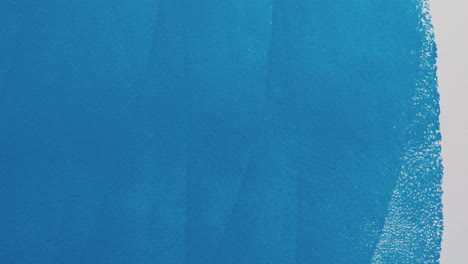 painting a wall blue with a paint roller