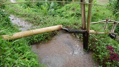 Ein-Cleveres-Gerät-Aus-Bambus,-Das-Umkippt,-Wenn-Das-Wasser-Im-Rohr-Voll-Ist,-Und-Es-In-Den-Darunter-Liegenden-Teich-Fallen-Lässt