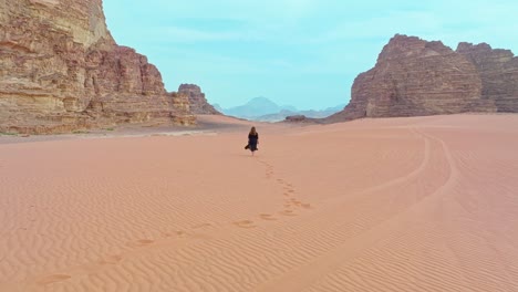 woman strolling on arid desert of wadi rum in aqaba, jordan