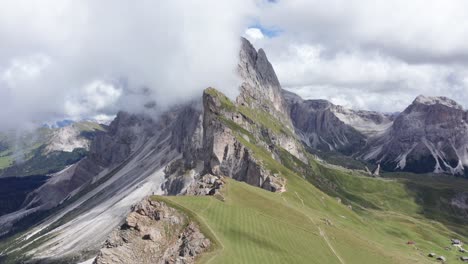 drone panoramic shot over gigantic mountains surrounded by white clouds at secedar idgeline hike path in puez national park