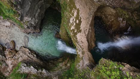 un hombre trepando por las rocas de la cascada en ujëvara e peshturës albania