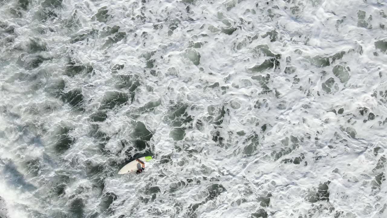 공중 - 파도를 타기 위해 기다리는 서퍼를 똑바로 내려다보고 있습니다.