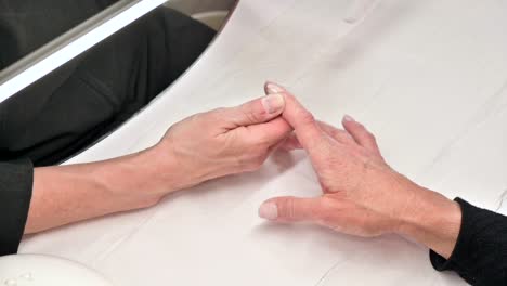 Closeup-shot-of-a-woman-in-a-nail-salon-receiving-a-manicure-by-a-beautician-with-a-nail-file