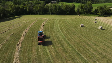 tractor harvesting field with straw harvester, agriculture summer, aerial