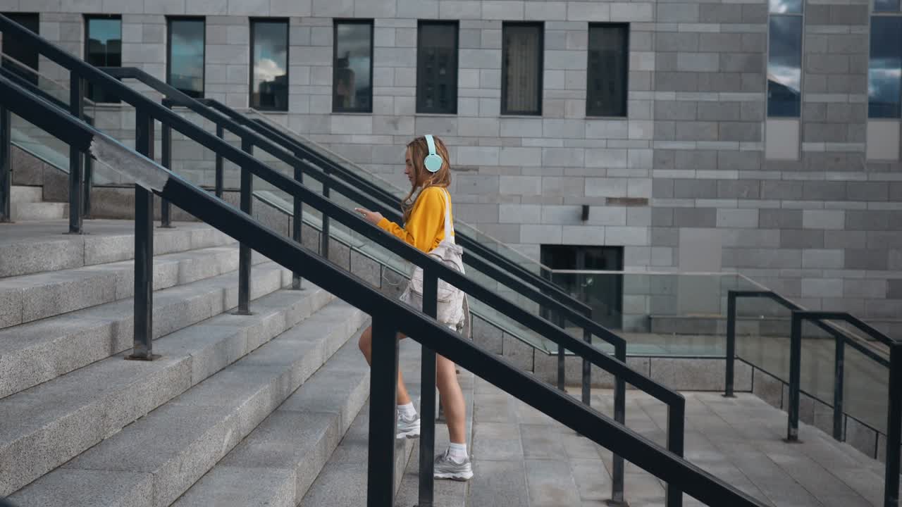 retrato de una joven linda y atractiva en las calles de la ciudad urbana fondo escuchando música con auriculares. mujer con blusa amarilla y falda plateada