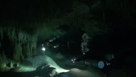 cave divers signal toward the exit