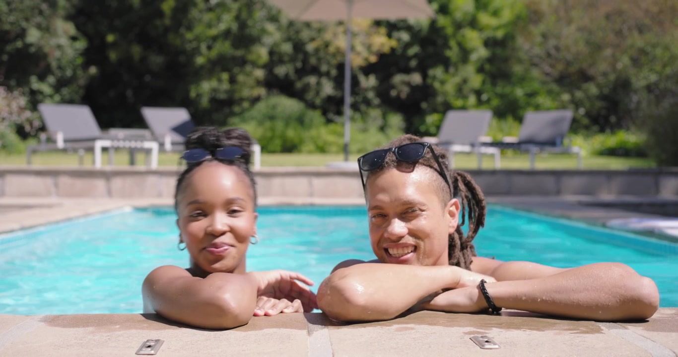 African American couple woman laughing man listening touching whispering tucking sunglasses at pool