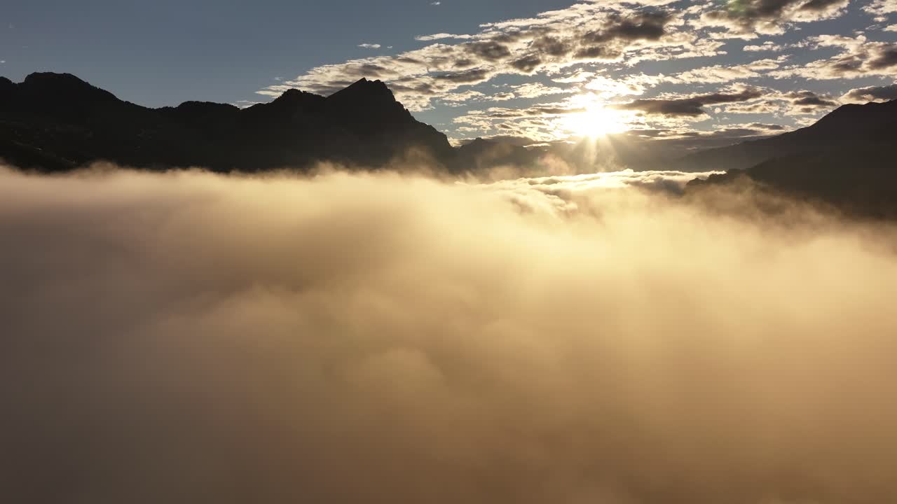 An aerial view reveals a foggy and misty layer hovering above Lake Walensee in Switzerland, creating a dreamlike landscape.