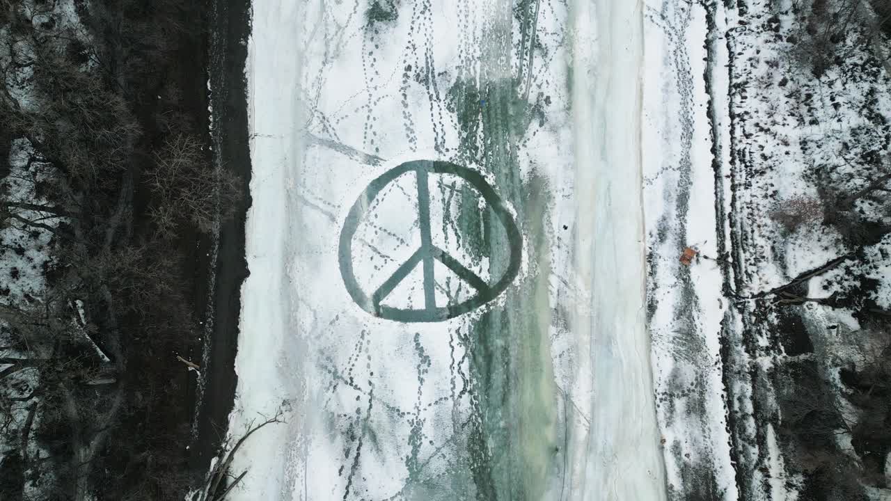 A Static 4k Shot of a Large Overhead Plowed Snow Peace Sign on Frozen Ice River Outdoors