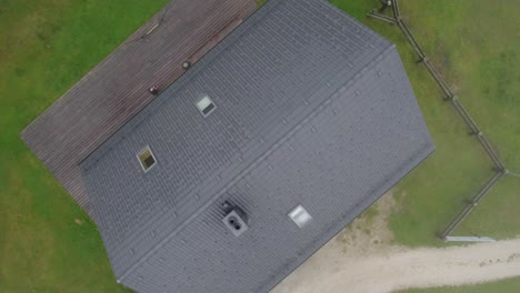 Bird's-eye-view-of-small-mountain-hut-disappearing-in-fog-in-Lavanttal,-Austria