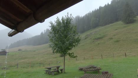 fuertes lluvias en las montañas vistas desde el refugio bajo el techo, goteo de agua desde la canaleta