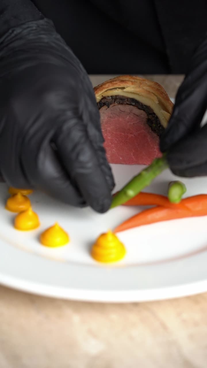 En kok tilbereder skiveskåret Beef Wellington, nærbillede, indskudsbillede
