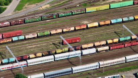 Vista-Aérea-De-Un-Vagón-De-Carga-Rojo-Sin-Locomotora-Que-Se-Mueve-Sobre-Las-Vías-De-Una-Estación-De-Tren