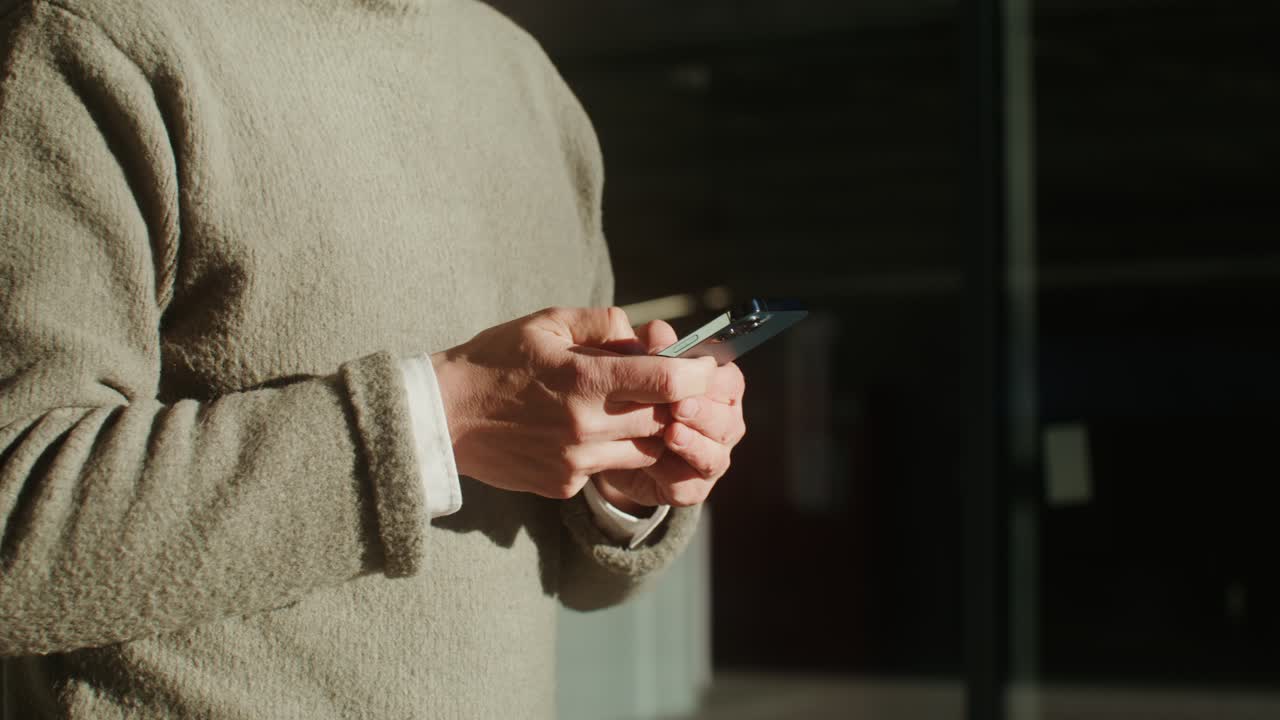 Uomo che usa lo smartphone in casa