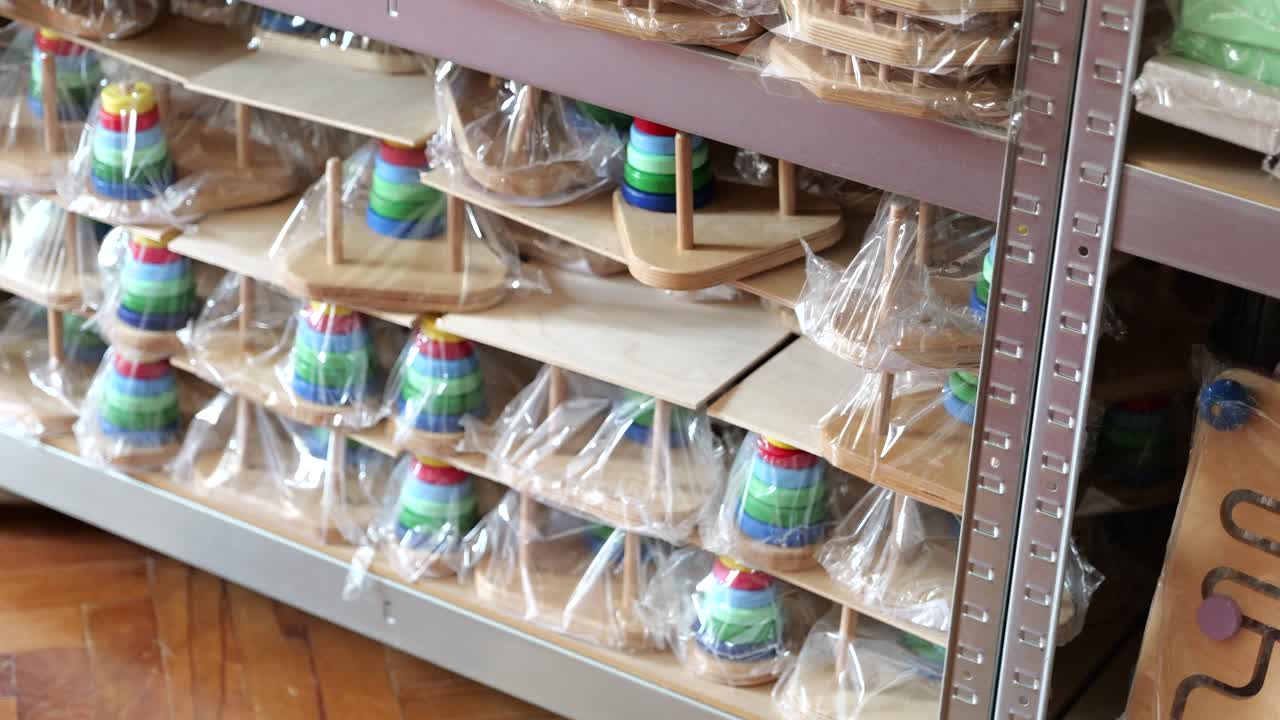 게임 공장에서 선반에 보관된 포장된 나무 게임과 퍼즐의 줄