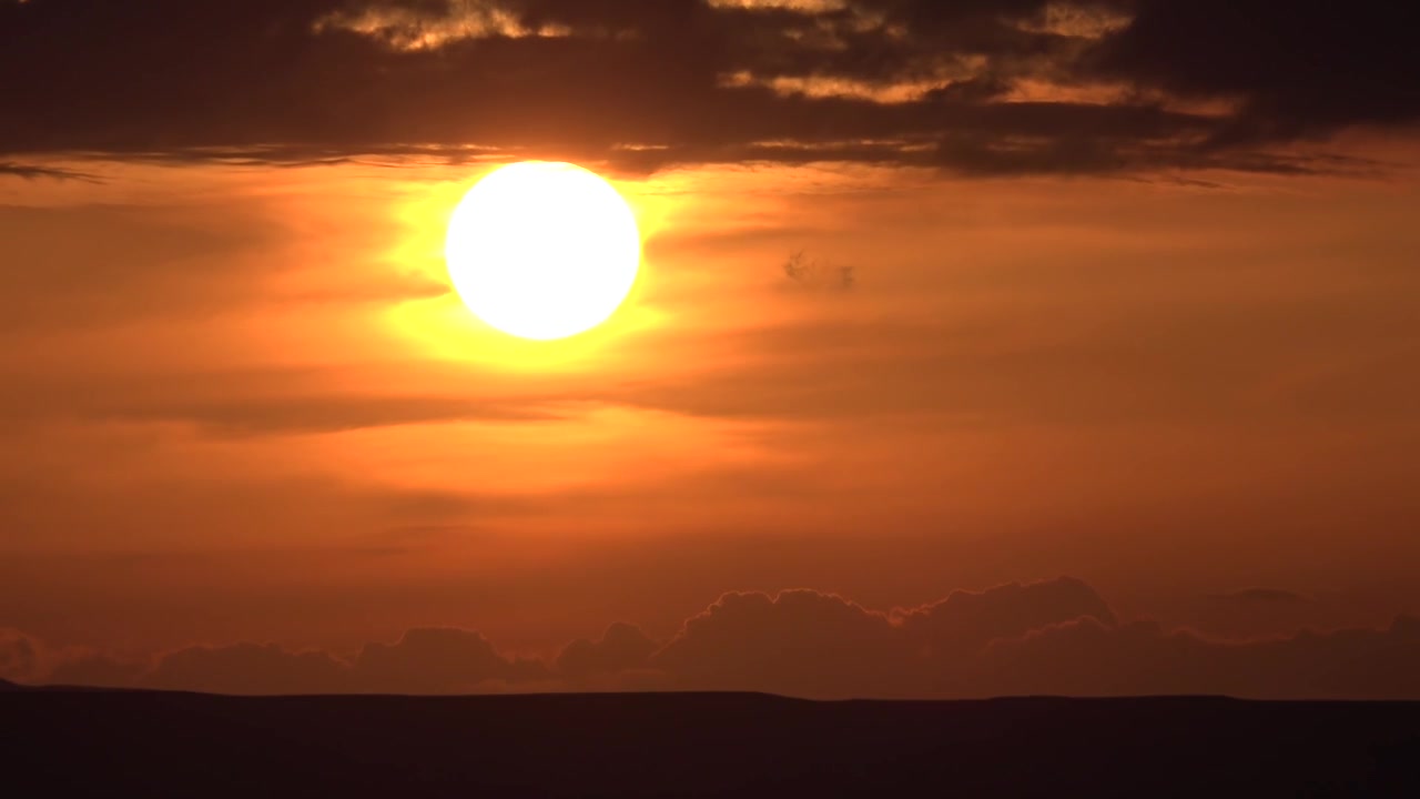 Time-lapse af en dramatisk solnedgang over horisonten