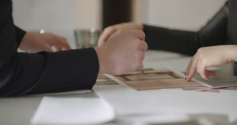 business people signing contracts together concluding deal by firm handshake