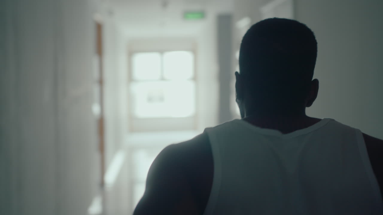 Black Basketball Player Walking along Corridor and Practicing Ball Handling