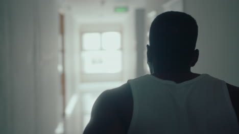 black basketball player walking along corridor and practicing ball handling