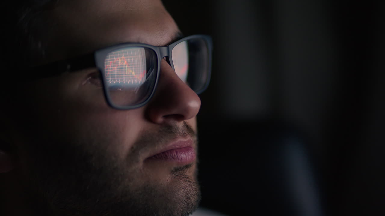 primer plano de las gafas hombre. inversor viendo el cambio de la bolsa de valores en la pantalla del portátil. comerciante superior mira gráficos corriendo análisis de datos para hacer la mejor venta. lleno de pantallas y estadísticas