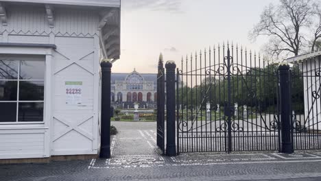 entrance gate to a palace garden with small keeper's house and black gate with beautiful park, cologne, flora, germany