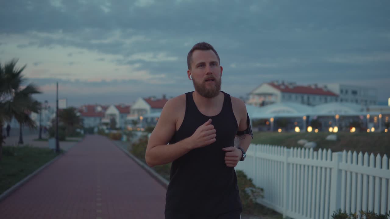 hombre corriendo por el camino costero al atardecer