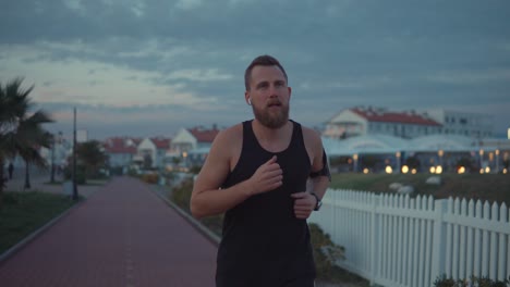 hombre corriendo por el camino costero al atardecer
