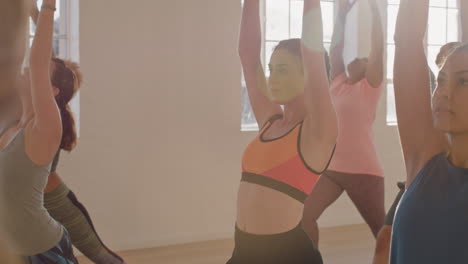 clase de yoga grupo de jóvenes sanos que practican pose de guerrero disfrutando del estilo de vida físico haciendo ejercicio en el estudio al amanecer