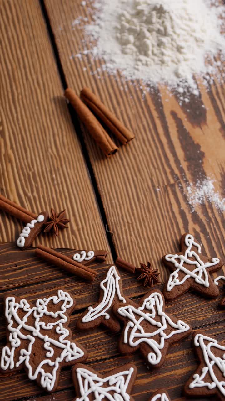 Top-down video shot of intricately iced star cookies on rustic wood, with flour and cinnamon sticks