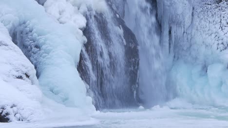 Helgufoss-water-covered-in-ice,-with-snow-falling