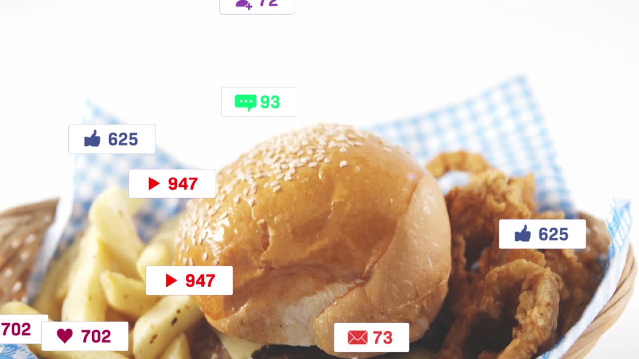 Social media notifications animation over burger and fries on checkered cloth