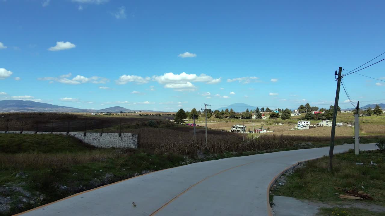 멕시코 주 알몰로야의 시골 지역의 외로운 도로에서 단독 드론이  ⁇ 리를  ⁇ 았습니다. 농장과 작물이 분리되어 있습니다.